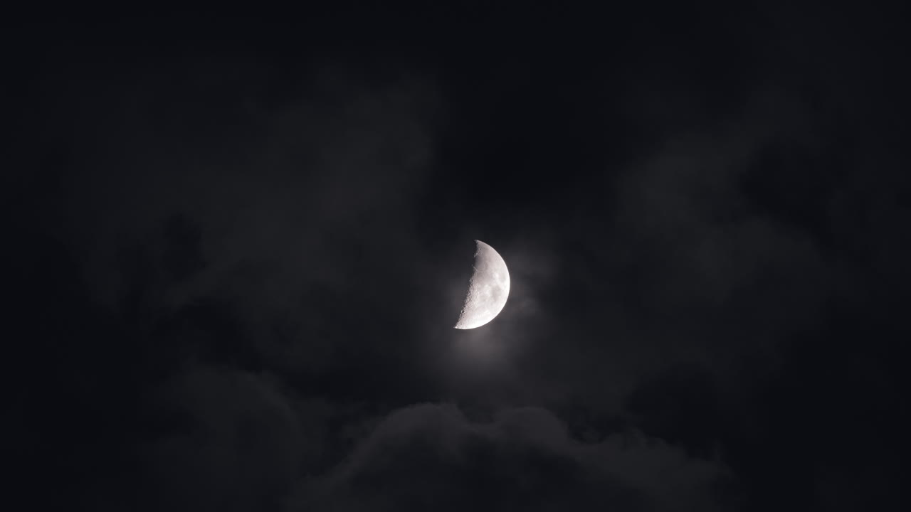 Crescent Moon Through Clouds at Night