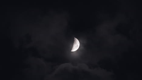 crescent moon through clouds at night