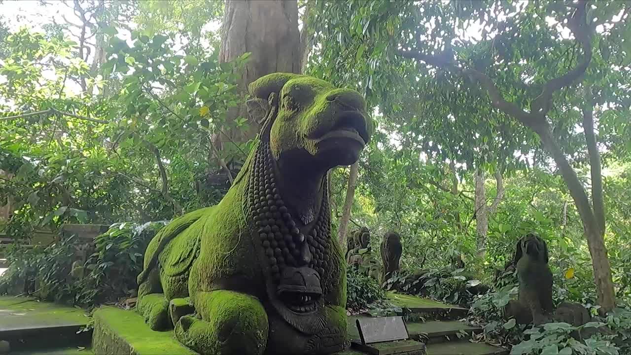 escultura de piedra de vaca divina cubierta de musgo en el bosque de los monos en ubud, bali, indonesia