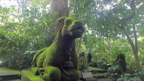 divine cow stone sculpture covered in moss at monkey forest in ubud bali indonesia