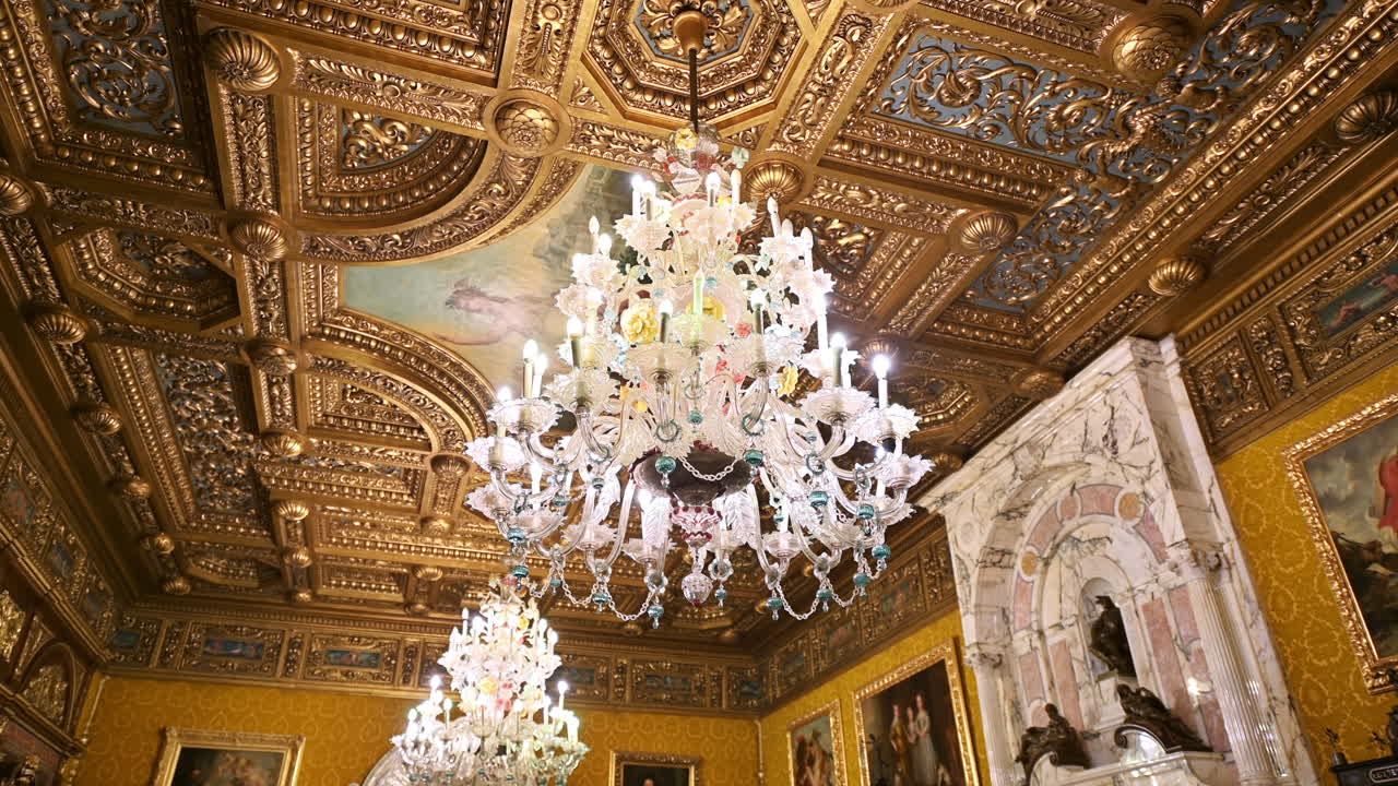 Interno del Castello di Peleș in Romania. Una stanza con un design classico, dettagli dorati e lampadari