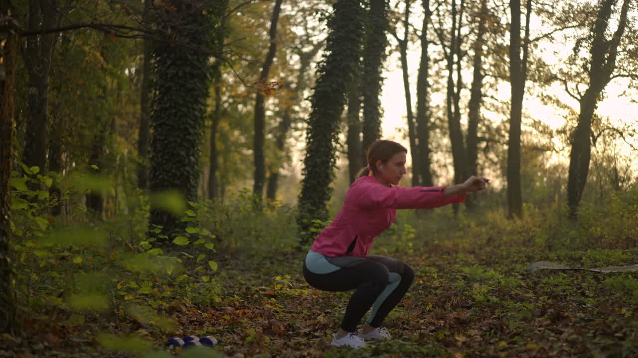 Woman Doing Squats Exercise in an Autumn Forest