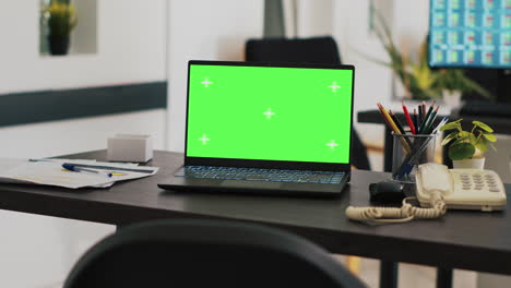 mockup notebook in office and screen in background displaying trading platform