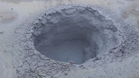 a crater of bubbling grey mud in an icelandic geothermal area - slow motion