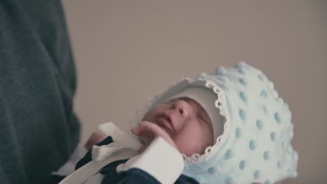 young father holds cute baby in tuxedo and warm hat closeup