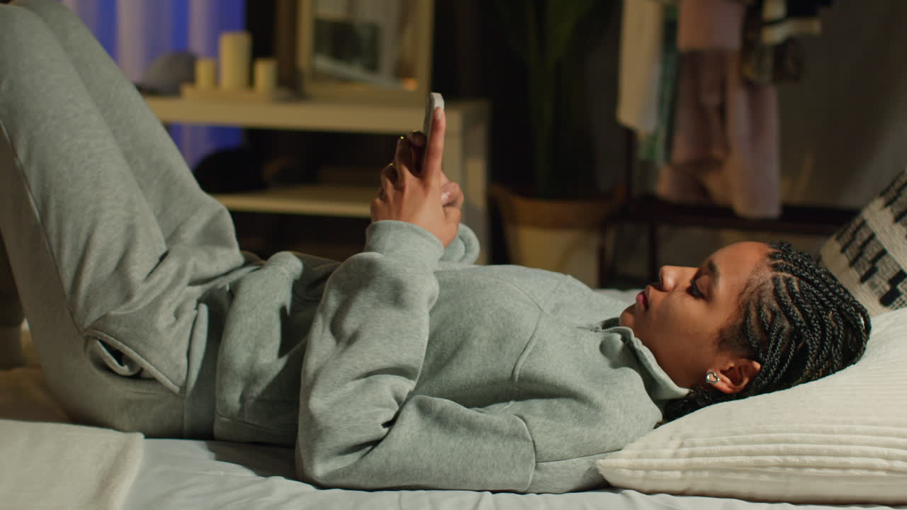 Teenager using smartphone in bed at night
