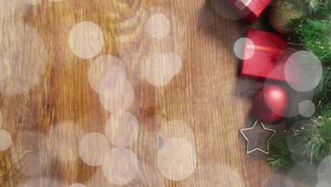 Christmas decorations with red gifts and bokeh lights animation on wooden background