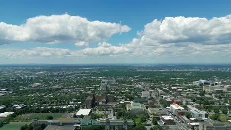 4k cinematic urban landscape footage of a drone flying around the observatory saint joseph in montreal, quebec on a sunny day, behind mount royal capturing a beautiful panoramic view