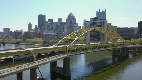 aerial shot moving from river to reveal pittsburgh bridge and skyline