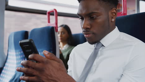 Mujer-De-Negocios-Sentada-En-El-Tren-Viajando-Al-Trabajo-Revisando-Mensajes-En-El-Teléfono-Móvil