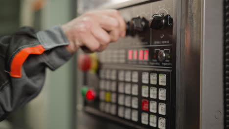 close-up of a technician programming cnc machine with digital control panel