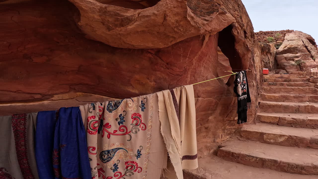 Traditional Arabic clothes hanging on the rope. Little shop of souvenirs in the ruins of the ancient city. Jordan, West Asia.