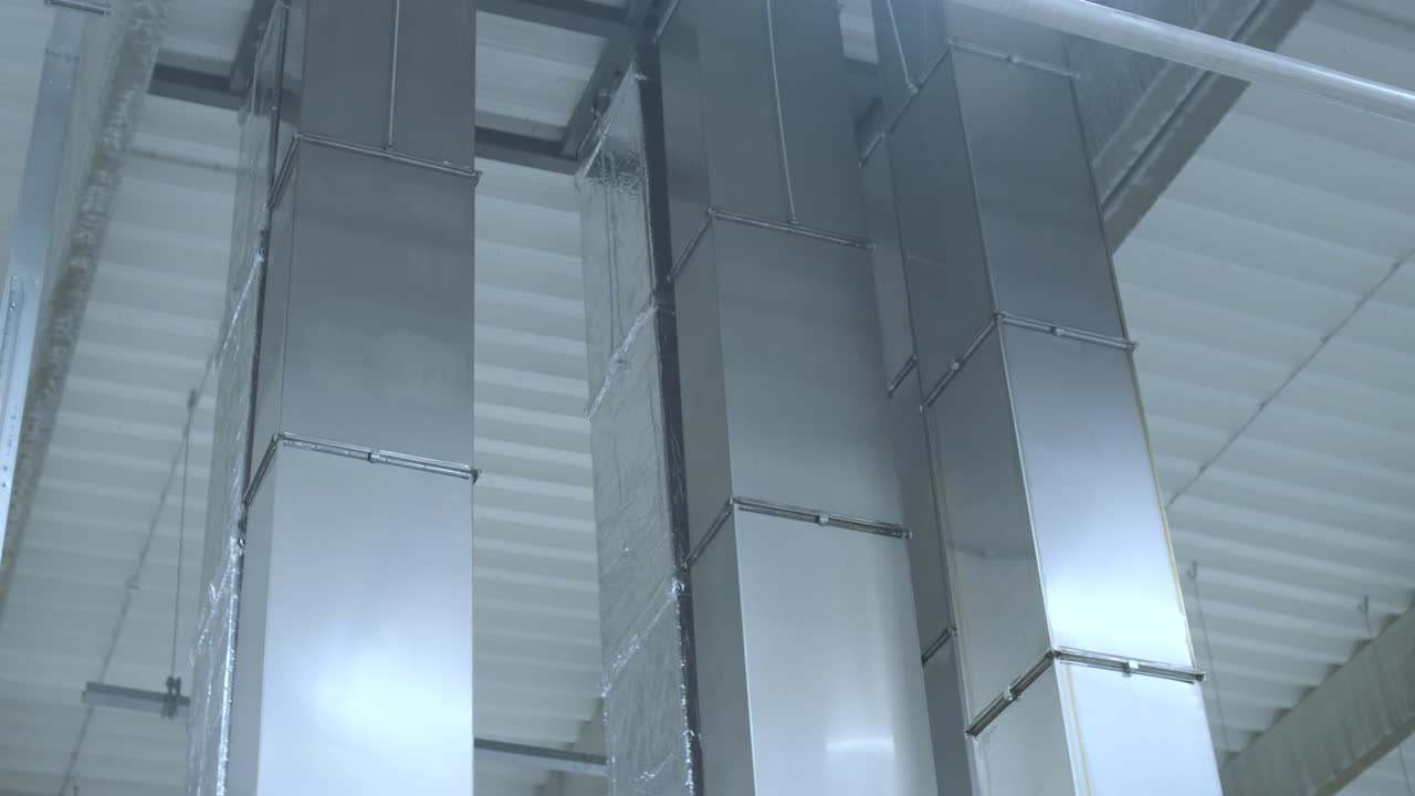 limpieza de conductos de aire acondicionado, tuberías de ventilación en material aislante de plata colgando del techo dentro de un edificio nuevo.