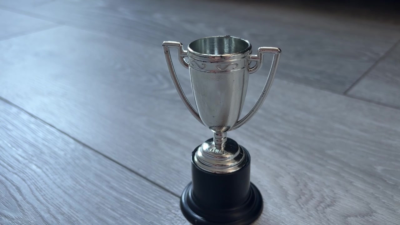 Primo piano di una piccola coppa trofeo d'argento sul pavimento