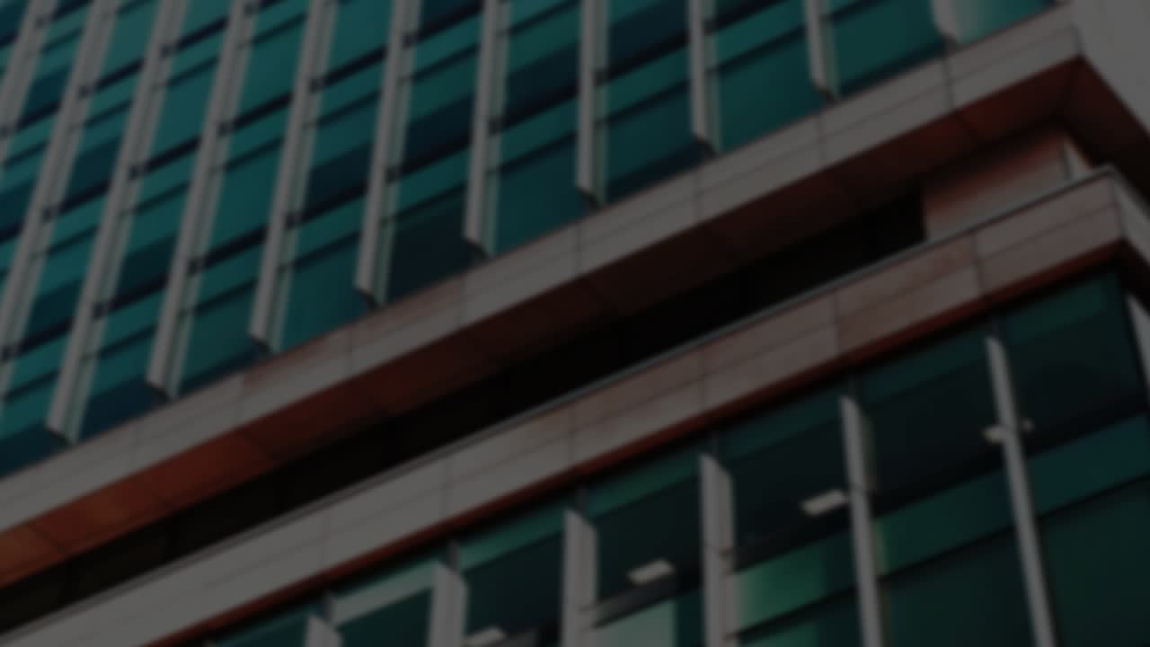 Faint green fragments sparking neon pound forming and pulsing over glass facade to visualize money