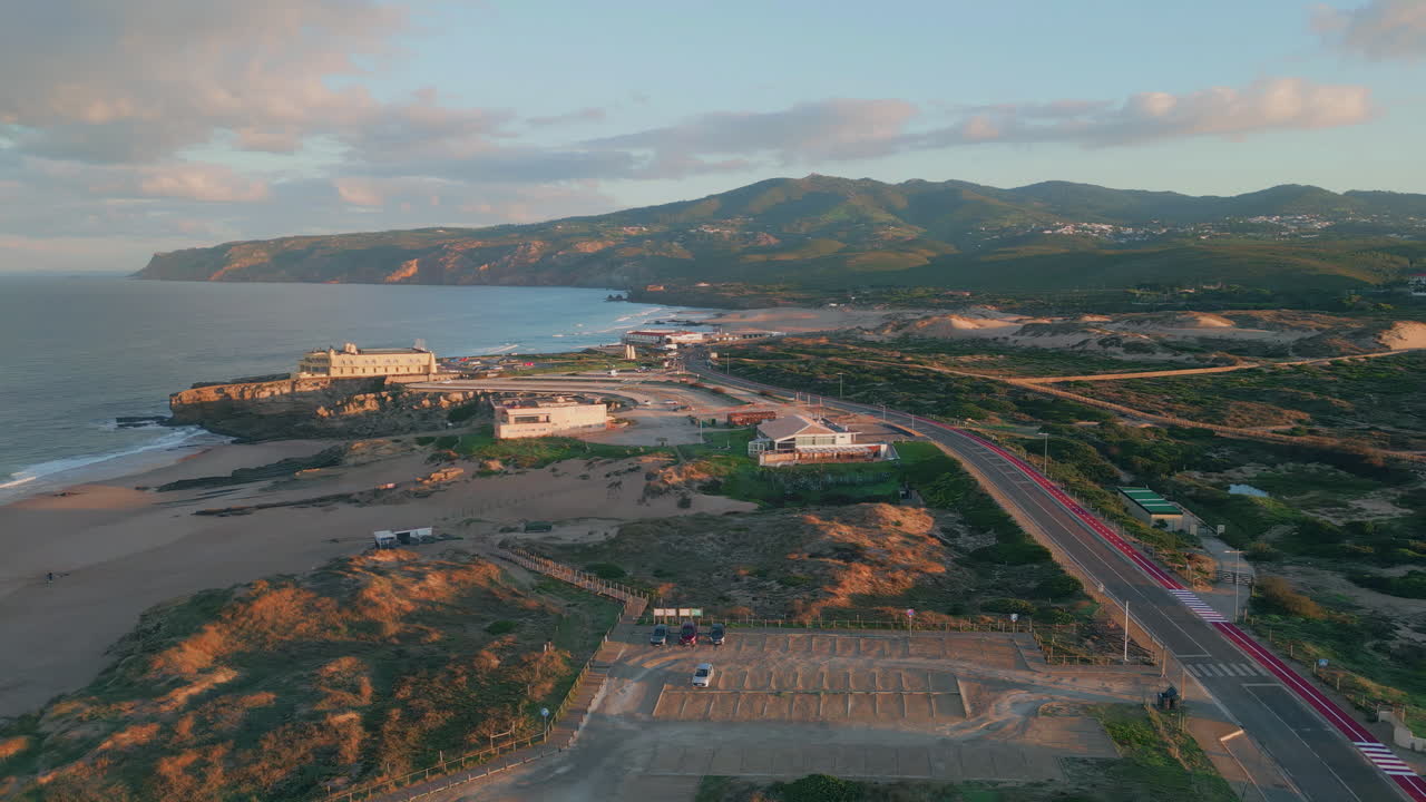 Coastal town morning light aerial view. Peaceful waves meeting sand shore scene.