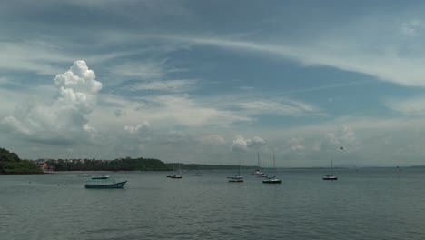 Toma-Estática-De-Un-Hermoso-Lago-Con-Aguas-Tranquilas,-Muchos-Botes-Flotantes-Individuales-Y-Una-Vista-De-Las-Grandes-Nubes-En-El-Cielo-En-Un-Día-De-Verano