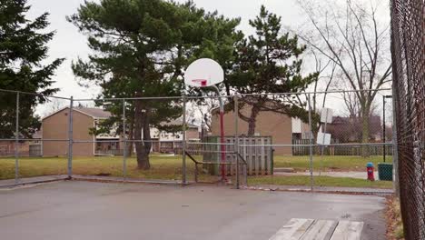 a small basketball court on an overcast day in a neighborhood suburb