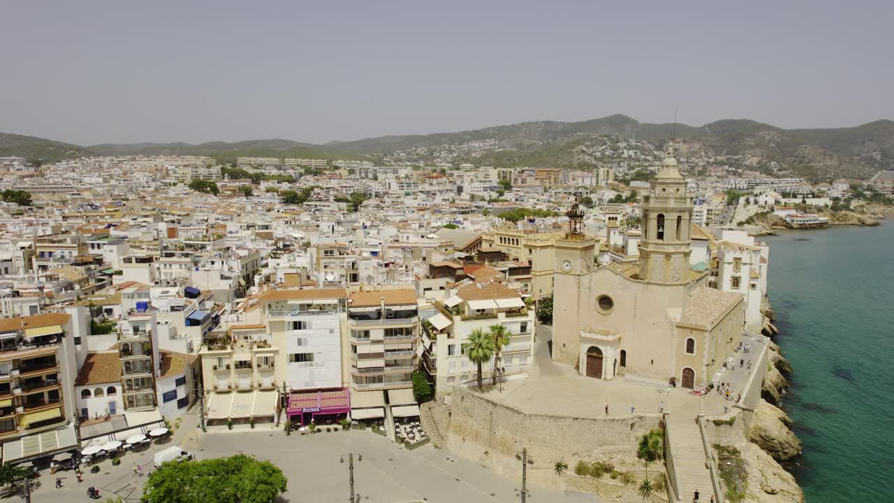 Aerial view of a picturesque Mediterranean coastal town with a prominent church by the sea