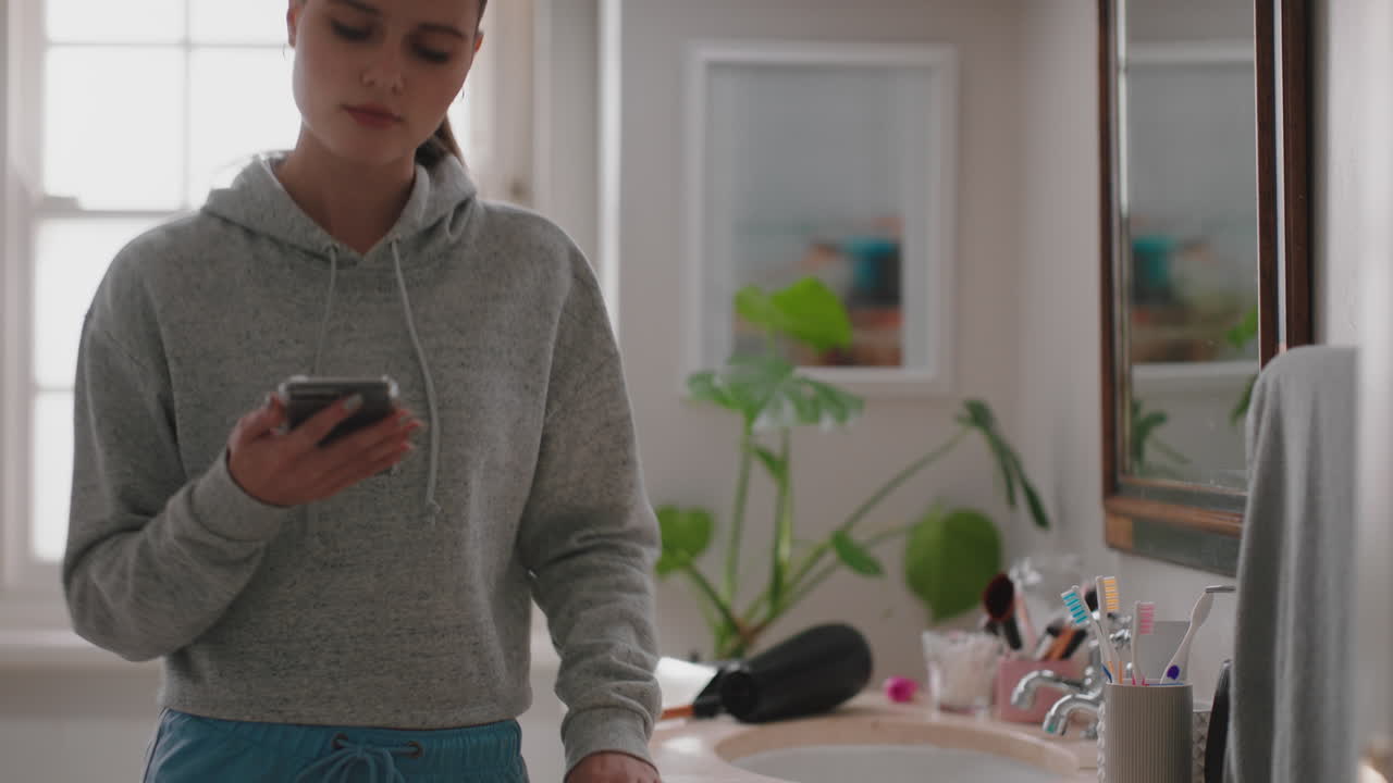 hermosa adolescente mirándose en el espejo preparándose aplicando maquillaje en el baño
