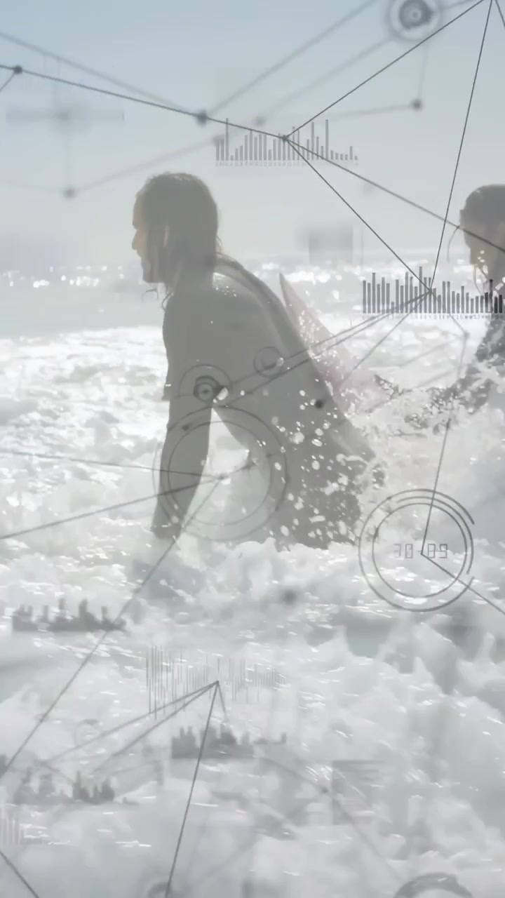 Pystyvideo: Surffiduo polvistuu rannalla, johtava surffaaja työntää lautaa vaahtoon, valmistautuu, HUD-seuranta.