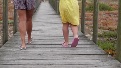 people walking in the walkway to the beach