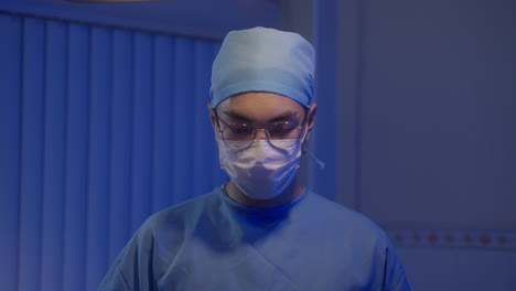 hospital doctor in glasses and complete scrubs look at the camera