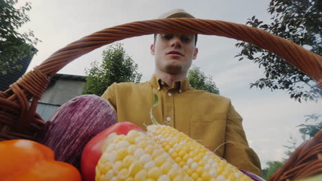 hombre sosteniendo una canasta de verduras frescas