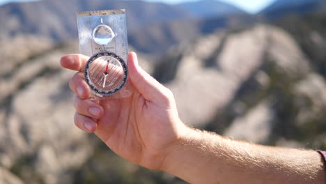 a man holding a survival compass to find his location and the direction he is searching for in life