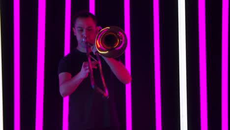 man playing trombone under blue neon lights