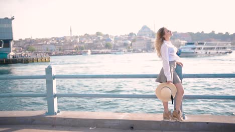 beautiful girl stands over galata bridge and enjoys view of bosphorus in istanbul,turkey