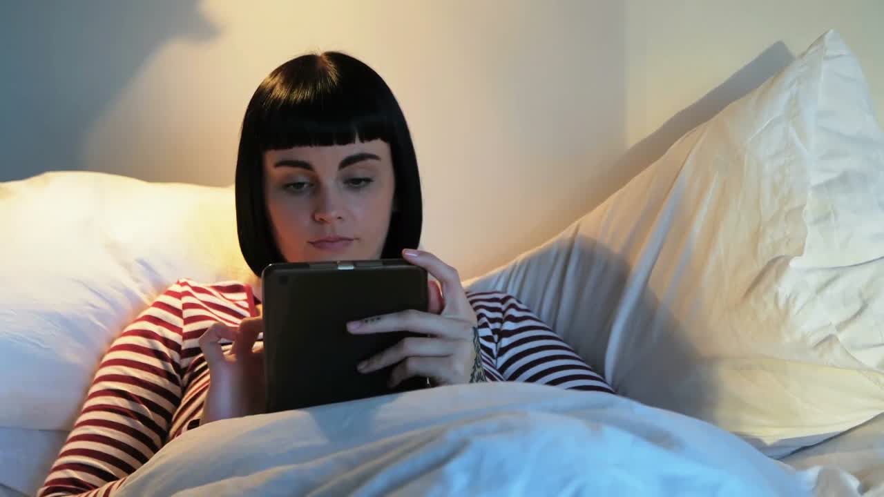 Woman using digital tablet in bedroom 4k
