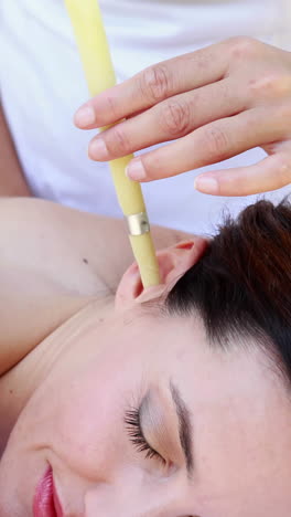 relaxed brunette getting an ear candling treatment