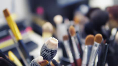 conjunto de pinceles para maquillaje en la mesa en el vestuario. industria de la moda. desfile de moda entre bastidores. toma en cámara lenta