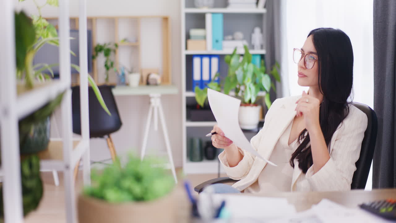 자신감 있는 사업가 여성이 사무실에서 재정 문서를 분석합니다.
