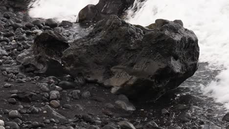 fotografía de cerca de las grandes rocas volcánicas negras que quedan en la isla de hachijo de una erupción