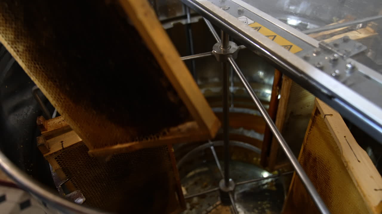 Beekeeper loading wooden honey frames into the centrifuge machine. Preparation for honey extraction process. Top view.