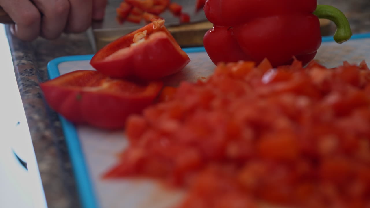 나무 보드에 칼 절단 신선한 고추와 남자 손의 근접 촬영