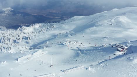 breathtaking beauty of the mountain in winter and people skiing on the slope on an overcast day