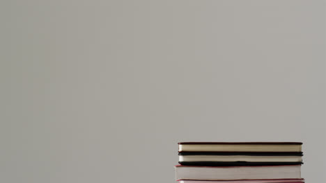 primer plano de una pila de libros con espacio de copia en un fondo gris, en cámara lenta