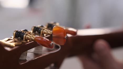 vista única de las teclas de afinación de una guitarra mientras toca un músico