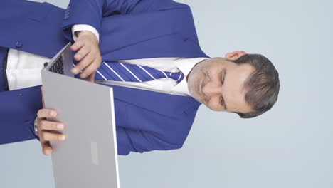 Vertical-video-of-Satisfied-businessman-looks-at-laptop-and-approves.