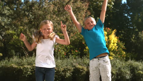 siblings jumping at the same time in their garden