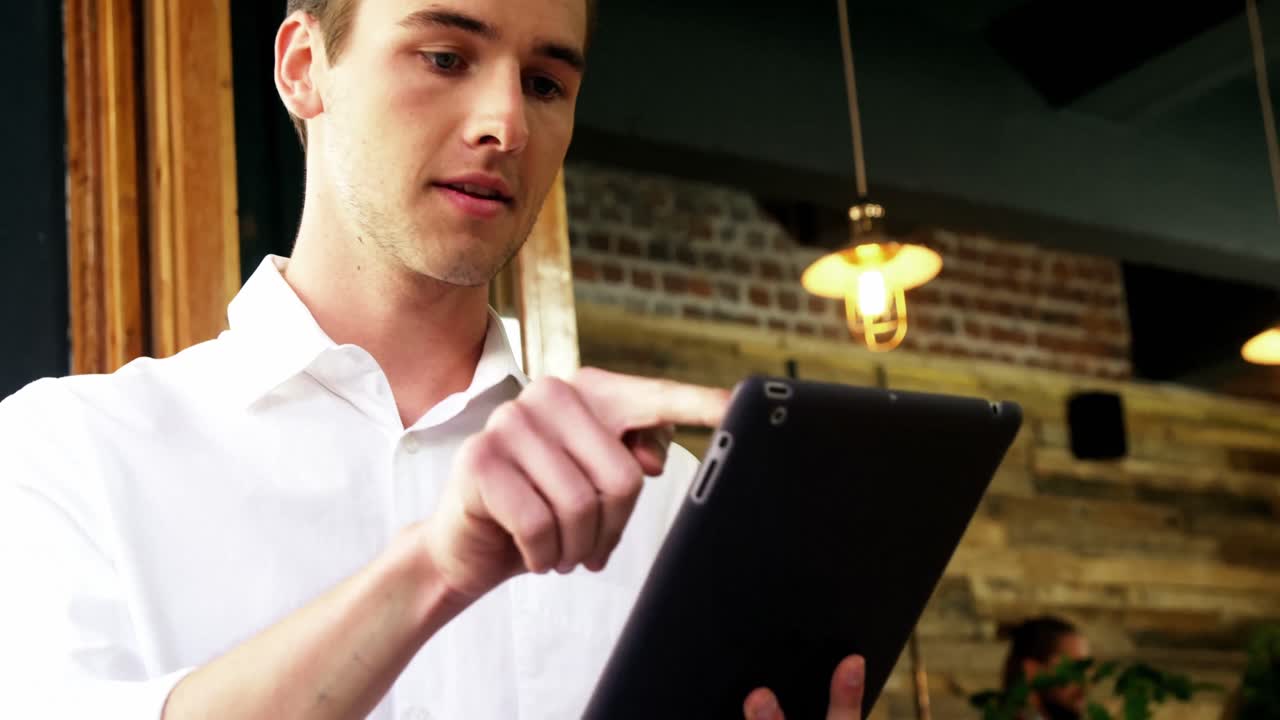 Male customer using digital tablet in caf&Atilde;&copy;