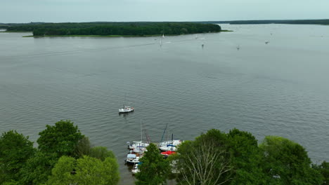 aerial view of a marina on jeziorak lake in siemiany, poland, with boats docked near the shoreline and a wide expanse of water leading to distant islands