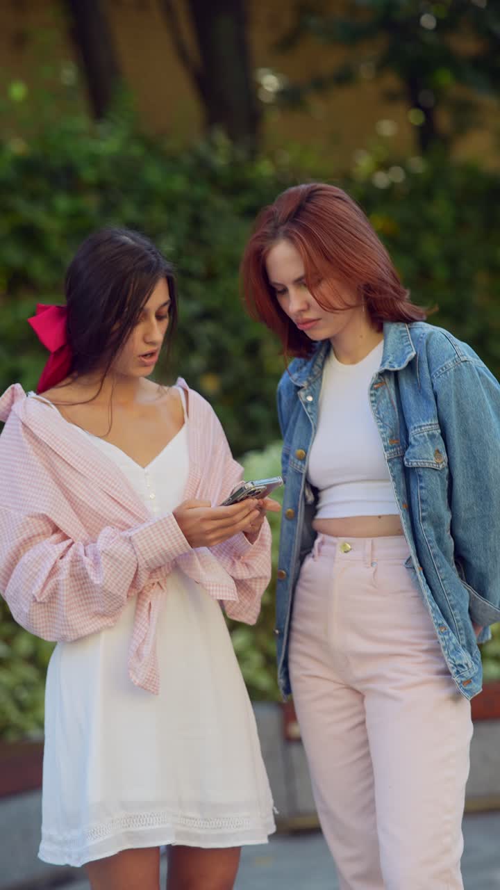 dos mujeres jóvenes mirando un teléfono