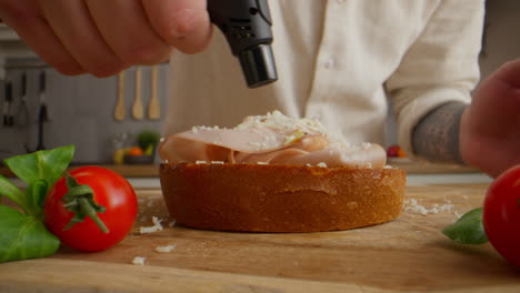 preparing a grilled ham and cheese sandwich with a kitchen torch