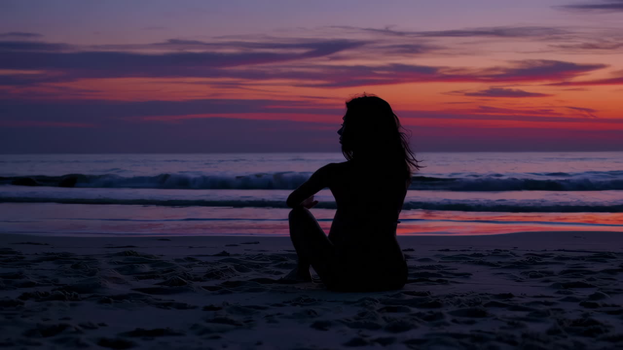 Woman Sitting on Beach at Sunrise/Sunset
