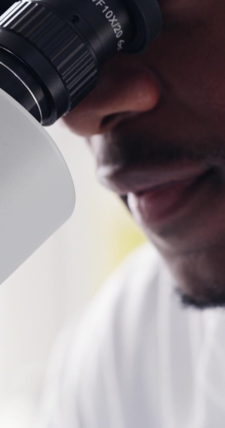 Scienziato che usa siringa e microscopio in laboratorio
