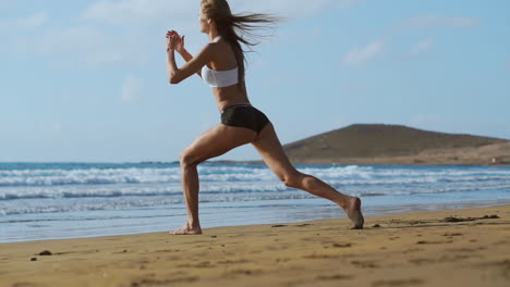 chica deportiva en una playa haciendo ejercicios de estocadas. concepto de un estilo de vida saludable